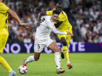 Jude Bellingham of Real Madrid CF (L) is in action with the ball against Pape Gueye of Villarreal CF (R) during the La Liga EA Sports 2024/2...