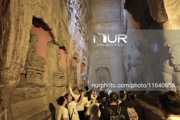 Tourists visit the Xiangtang Mountain Grottoes in Handan, China, on October 5, 2024. 