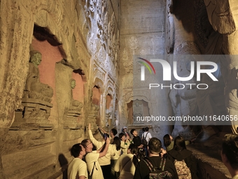 Tourists visit the Xiangtang Mountain Grottoes in Handan, China, on October 5, 2024. (