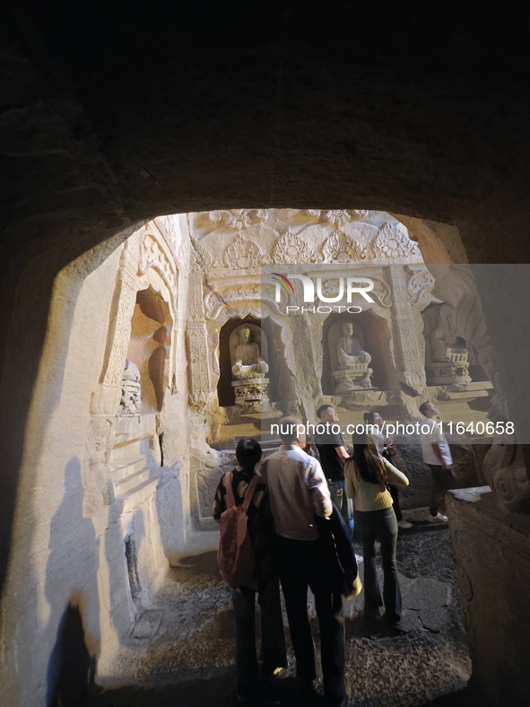 Tourists visit the Xiangtang Mountain Grottoes in Handan, China, on October 5, 2024. 