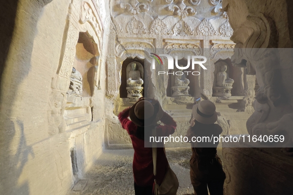 Tourists visit the Xiangtang Mountain Grottoes in Handan, China, on October 5, 2024. 