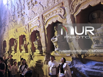 Tourists visit the Xiangtang Mountain Grottoes in Handan, China, on October 5, 2024. (