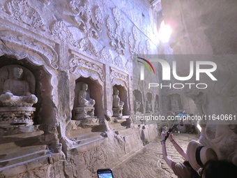 Tourists visit the Xiangtang Mountain Grottoes in Handan, China, on October 5, 2024. (