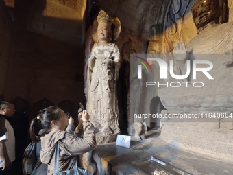 Tourists visit the Xiangtang Mountain Grottoes in Handan, China, on October 5, 2024. (