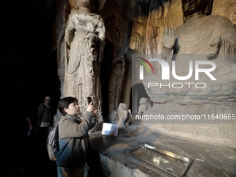 Tourists visit the Xiangtang Mountain Grottoes in Handan, China, on October 5, 2024. (