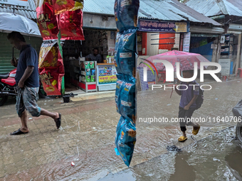 Children return from school during heavy rain in Feni, Bangladesh, on October 6, 2024. Climate change makes monsoons more extreme. Monsoons...