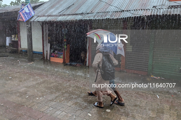 Children return from school during heavy rain in Feni, Bangladesh, on October 6, 2024. Climate change makes monsoons more extreme. Monsoons...