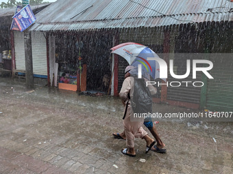 Children return from school during heavy rain in Feni, Bangladesh, on October 6, 2024. Climate change makes monsoons more extreme. Monsoons...