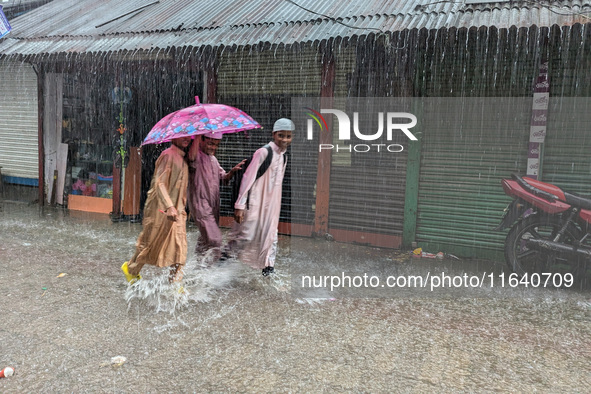 Children return from school during heavy rain in Feni, Bangladesh, on October 6, 2024. Climate change makes monsoons more extreme. Monsoons...