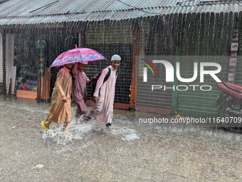 Children return from school during heavy rain in Feni, Bangladesh, on October 6, 2024. Climate change makes monsoons more extreme. Monsoons...