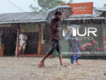 Children return from school during heavy rain in Feni, Bangladesh, on October 6, 2024. Climate change makes monsoons more extreme. Monsoons...