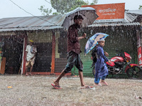 Children return from school during heavy rain in Feni, Bangladesh, on October 6, 2024. Climate change makes monsoons more extreme. Monsoons...