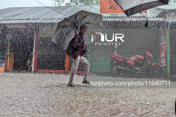 Children return from school during heavy rain in Feni, Bangladesh, on October 6, 2024. Climate change makes monsoons more extreme. Monsoons...