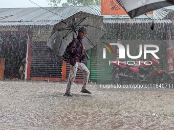 Children return from school during heavy rain in Feni, Bangladesh, on October 6, 2024. Climate change makes monsoons more extreme. Monsoons...