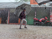 Children return from school during heavy rain in Feni, Bangladesh, on October 6, 2024. Climate change makes monsoons more extreme. Monsoons...