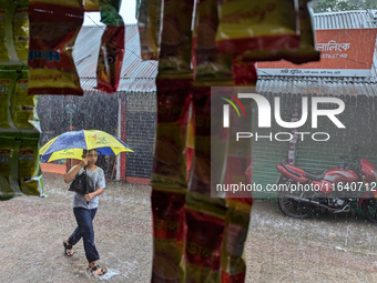 Children return from school during heavy rain in Feni, Bangladesh, on October 6, 2024. Climate change makes monsoons more extreme. Monsoons...