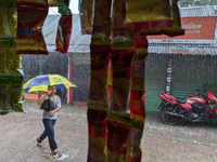 Children return from school during heavy rain in Feni, Bangladesh, on October 6, 2024. Climate change makes monsoons more extreme. Monsoons...