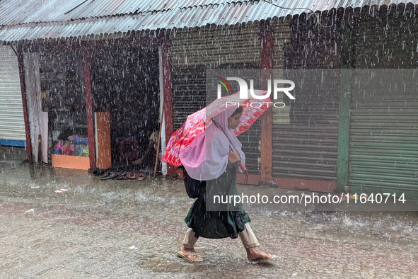 Children return from school during heavy rain in Feni, Bangladesh, on October 6, 2024. Climate change makes monsoons more extreme. Monsoons...