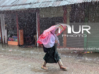 Children return from school during heavy rain in Feni, Bangladesh, on October 6, 2024. Climate change makes monsoons more extreme. Monsoons...