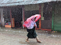 Children return from school during heavy rain in Feni, Bangladesh, on October 6, 2024. Climate change makes monsoons more extreme. Monsoons...