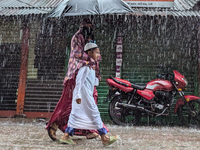 Children return from school during heavy rain in Feni, Bangladesh, on October 6, 2024. Climate change makes monsoons more extreme. Monsoons...