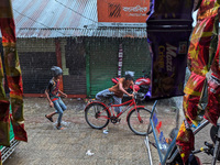 Children ride bicycles during heavy rain in Feni, Bangladesh, on October 6, 2024. Climate change makes monsoons more extreme. Monsoons becom...