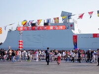 Tourists visit a warship at the port of the International Sailing Center in Qingdao, China, on October 3, 2024. (