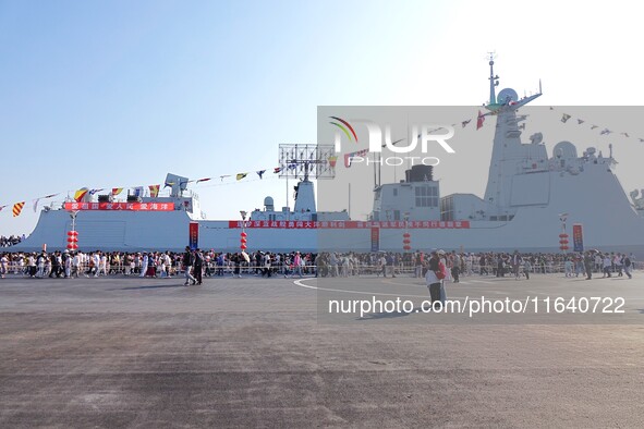 Tourists visit a warship at the port of the International Sailing Center in Qingdao, China, on October 3, 2024. 