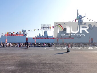 Tourists visit a warship at the port of the International Sailing Center in Qingdao, China, on October 3, 2024. (