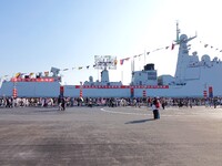 Tourists visit a warship at the port of the International Sailing Center in Qingdao, China, on October 3, 2024. (