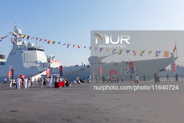 Tourists visit a warship at the port of the International Sailing Center in Qingdao, China, on October 3, 2024. 