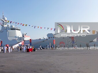 Tourists visit a warship at the port of the International Sailing Center in Qingdao, China, on October 3, 2024. (