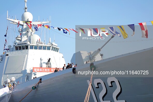 Tourists visit a warship at the port of the International Sailing Center in Qingdao, China, on October 3, 2024. 