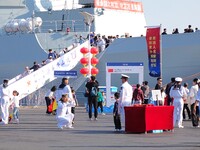 Tourists visit a warship at the port of the International Sailing Center in Qingdao, China, on October 3, 2024. (