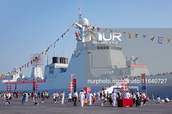 Tourists visit a warship at the port of the International Sailing Center in Qingdao, China, on October 3, 2024. 