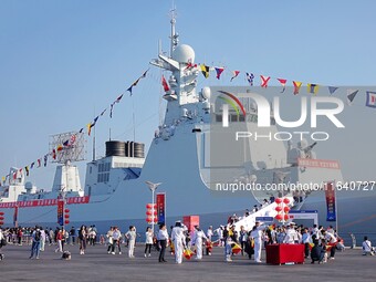 Tourists visit a warship at the port of the International Sailing Center in Qingdao, China, on October 3, 2024. (