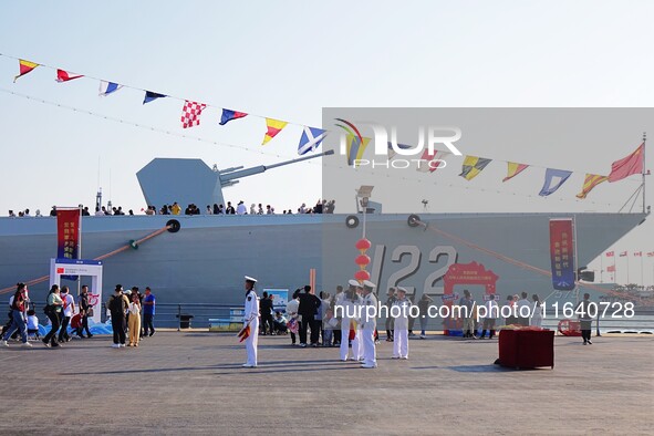 Tourists visit a warship at the port of the International Sailing Center in Qingdao, China, on October 3, 2024. 