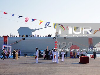 Tourists visit a warship at the port of the International Sailing Center in Qingdao, China, on October 3, 2024. (