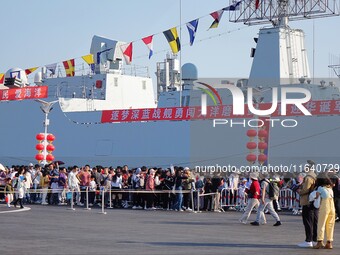 Tourists visit a warship at the port of the International Sailing Center in Qingdao, China, on October 3, 2024. (