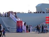 Tourists visit a warship at the port of the International Sailing Center in Qingdao, China, on October 3, 2024. (