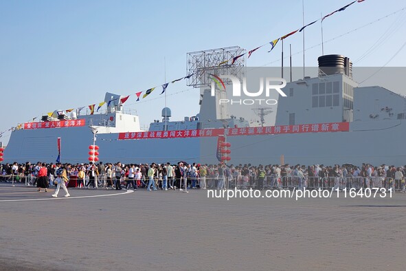 Tourists visit a warship at the port of the International Sailing Center in Qingdao, China, on October 3, 2024. 