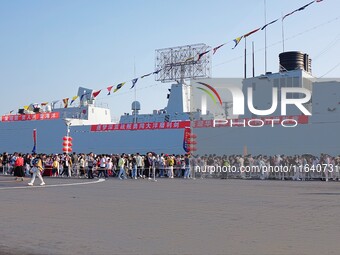 Tourists visit a warship at the port of the International Sailing Center in Qingdao, China, on October 3, 2024. (