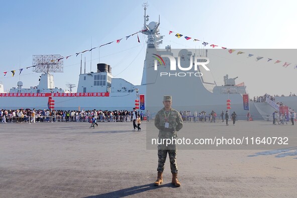 Tourists visit a warship at the port of the International Sailing Center in Qingdao, China, on October 3, 2024. 