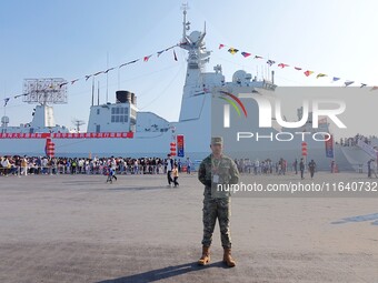 Tourists visit a warship at the port of the International Sailing Center in Qingdao, China, on October 3, 2024. (