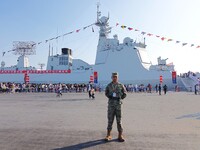 Tourists visit a warship at the port of the International Sailing Center in Qingdao, China, on October 3, 2024. (