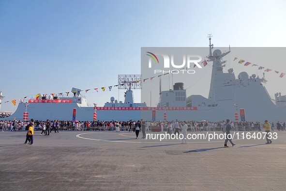 Tourists visit a warship at the port of the International Sailing Center in Qingdao, China, on October 3, 2024. 