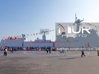 Tourists visit a warship at the port of the International Sailing Center in Qingdao, China, on October 3, 2024. (