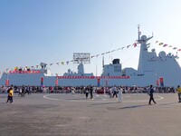 Tourists visit a warship at the port of the International Sailing Center in Qingdao, China, on October 3, 2024. (