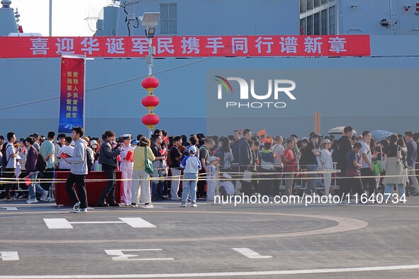 Tourists visit a warship at the port of the International Sailing Center in Qingdao, China, on October 3, 2024. 