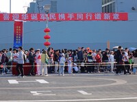 Tourists visit a warship at the port of the International Sailing Center in Qingdao, China, on October 3, 2024. (